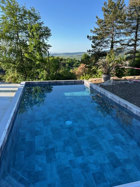 Pisciniste pour la construction d’une piscine rectangulaire à débordement de 7m x 3m avec fond plat à Saint-Denis-lès-Bourg